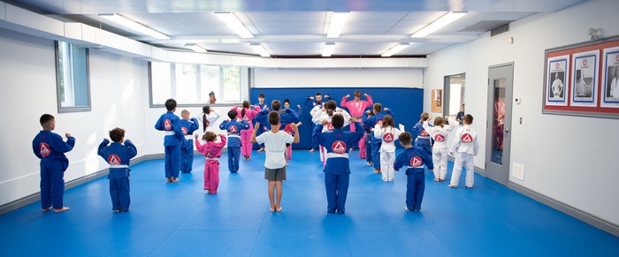 A full kids Brazilian Jiu-Jitsu class lined up on the mats at Gracie Barra Manotick