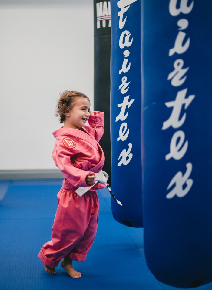 A young student smiling in her gi at Gracie Barra Manotick