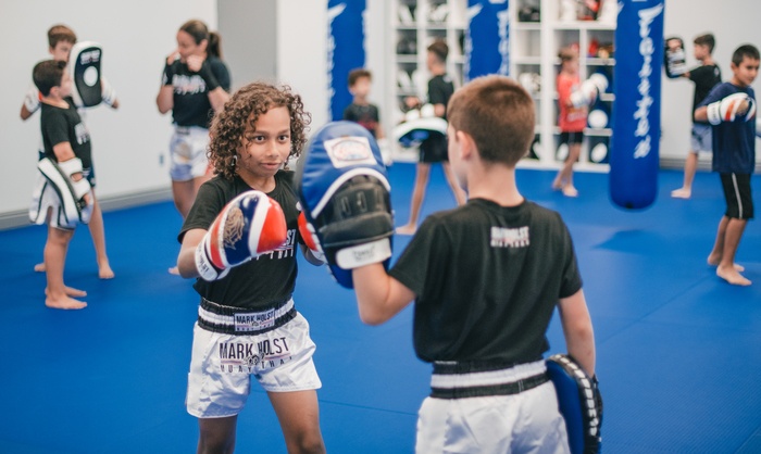 A young girl working focus mitts in a kids Muay Thai class